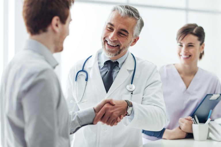 Médico conversando com paciente em ambiente de clínica, simbolizando acolhimento e confiança