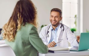 Relação médico paciente: por que os pacientes indicam você? 1 Médico em consulta com paciente em clínica, representando diálogo e suporte no atendimento