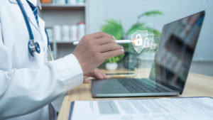 Médico usando uma caneta inteligente para mexer no notebook com hologramas de segurança a sua frente