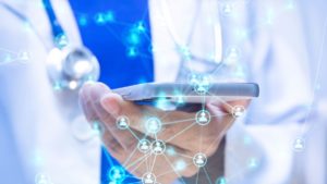 Médico usando um celular para usar as redes sociais da clínica