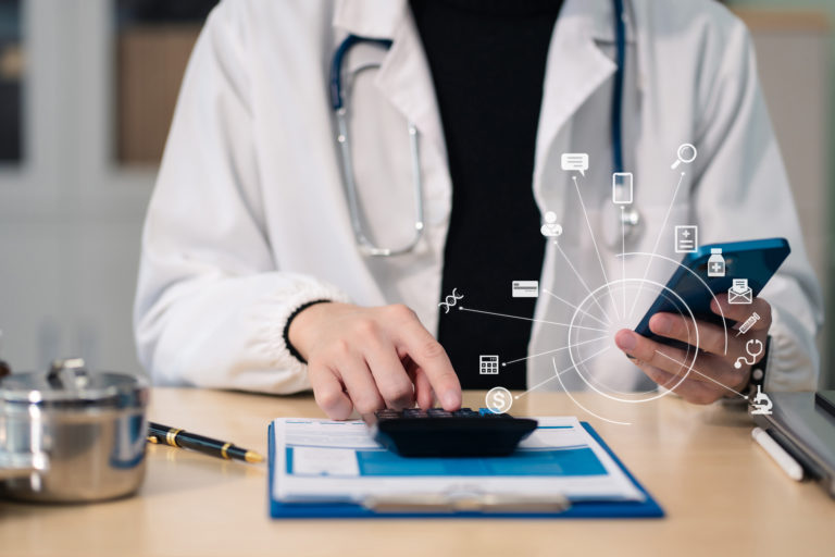 Médico usando uma calculadora para saber quanto de imposto de renda irá pagar