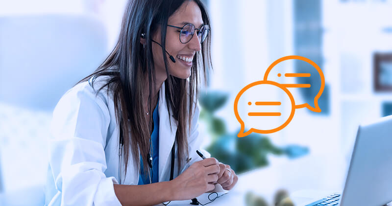 Médica usando um fone de ouvido em frente a um computador com holograma de mensagens laranja