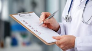 Médico marcando as funções administrativas em uma prancheta