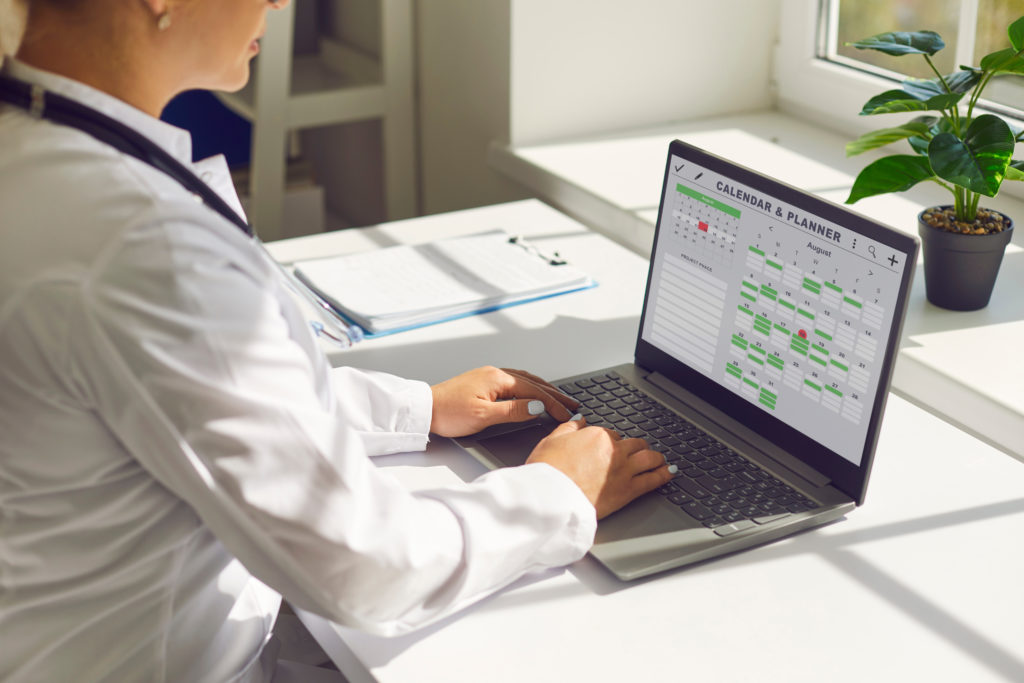 Médico em frente a um computador estudando aspectos administrativos da clínica