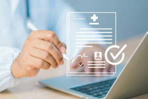 Médico em frente a um notebook realizando uma assinatura eletrônica