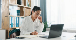 Médica em seu consultório analisando a sua agenda online em computador