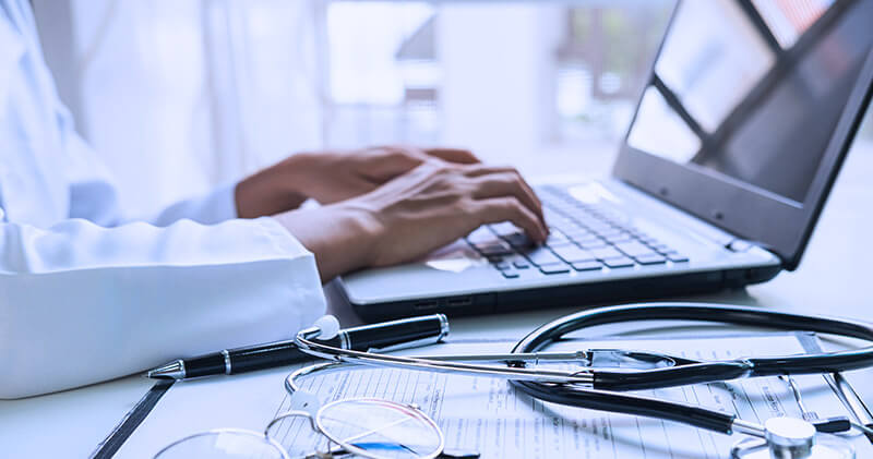 Como funcionam as tributações para médicos e clínicas? 10 tributacao para medicos mesa medica com computador