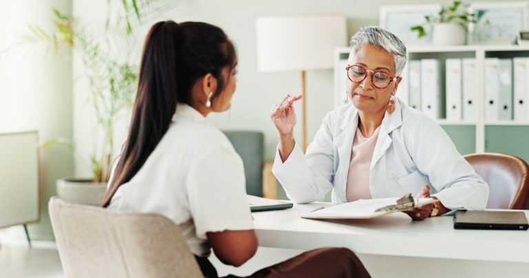 Médica dando um feedback estruturado para a recepcionista da clínica