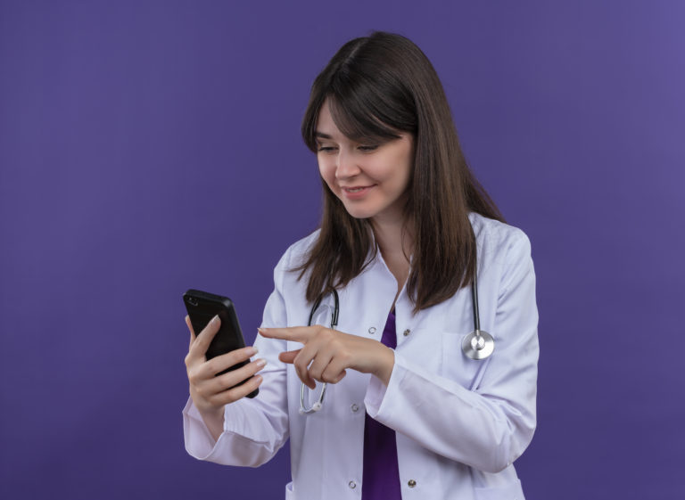 Médica utilizando celular para comunicação automatizada com pacientes