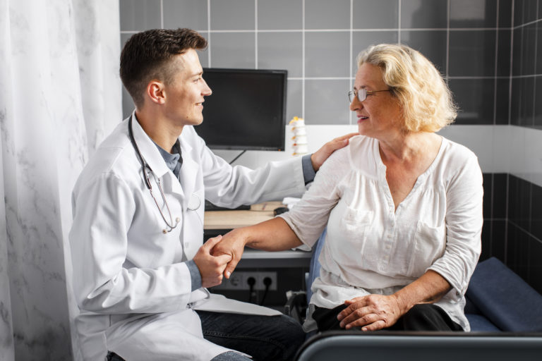 médico segurando a mão de paciente